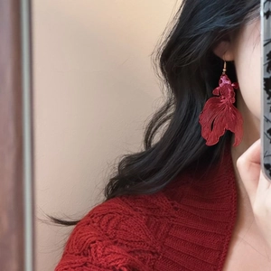 Detailed close-up of a red koi fish earring with embroidery and golden ear hook