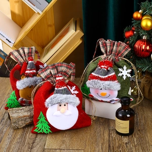 Christmas drawstring gift bags featuring Santa, snowman, and reindeer in red plaid design