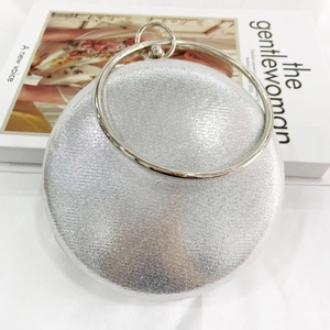 Detail of silver round evening clutch with glitter texture and metal ring handle