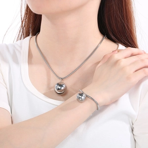 Detail of silver snake chain necklace and bracelet set with round beads on model