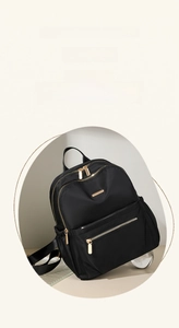 Close-up of high-density black nylon backpack with golden zippers and sleek metallic logo