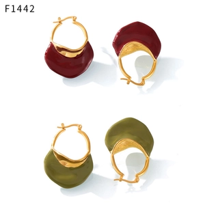 Macro detail of French vintage earrings with gold hoops and enamel wavy pendants