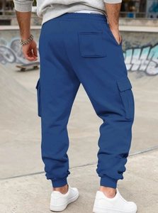 Rear view of blue cargo jogger pants showing pockets in an industrial street setting