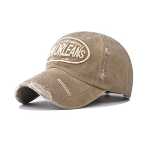 Detail of distressed washed cotton baseball cap with New Orleans embroidery and torn brim