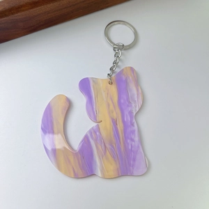 Detailed macro view of cat-shaped acrylic keychain with purple and yellow marble pattern