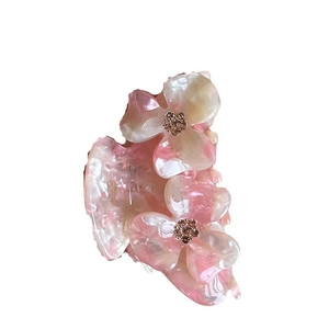 Pink and white gradient floral acetate hair claw clip with rhinestone center on white background