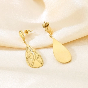 Macro detail of gold teardrop earrings with leaf veins and inlaid rhinestones