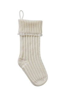 Detailed view of cream knitted Christmas stocking with ribbed texture and fringe tassel