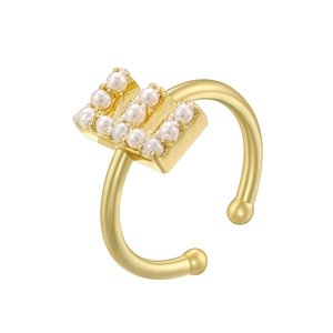Close-up of golden open ring featuring small pearls arranged in the letter H shape