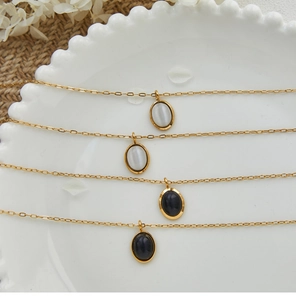 Detailansicht der ovalen Opal- und Onyx-Anhänger an goldenen Halsketten aus Edelstahl