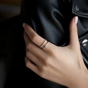 Close-up of a silver double T-shaped open ring with small zircon stones on a female model