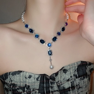 Détail du collier vintage avec pierres bleues ovales et gouttes de perles blanches