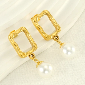Detail of vintage French style gold earrings featuring large round pearls in geometric frames