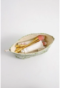 Macro detail of large capacity floral cosmetic bag showing interior storage for toiletries
