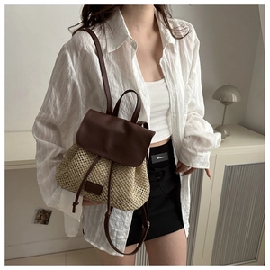 Detail of a two-tone woven backpack in brown and beige with leather flap and drawstring
