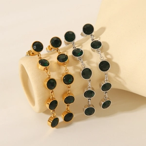18K gold plated stainless steel tassel drop earrings with green crystals on studio stand
