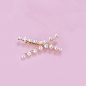 Crossed golden metal bobby pins with white pearl accents for hair styling set of two