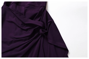Detailed view of the dark purple dress featuring a stylish twist knot and elegant pleats