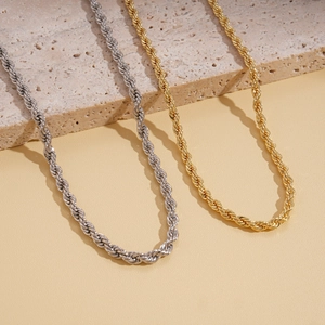 Detailed view of intertwined gold and silver twisted rope chains on beige stone