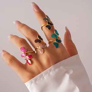 Detailed view of colorful enamel butterfly rings on hand with adjustable golden bands