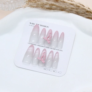 Pink gradient cat eye press-on nails with 3D bows in a long almond stiletto shape