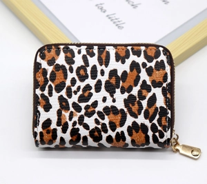 Detail of leopard print card holder with pebbled texture and gold zipper pull