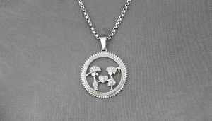 Close-up of a sparkling silver-colored couple pendant with boy and girl holding a heart