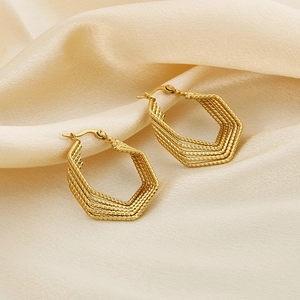 Golden multi-layer hexagonal twist earrings on beige silk, stylish geometric design