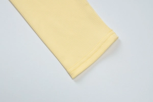 Gros plan détaillé des poignets en tricot côtelé et coutures du cardigan jaune clair