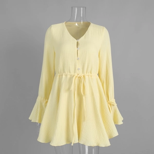 Detail of yellow cotton dress showing V-neckline with buttons and drawstring waist