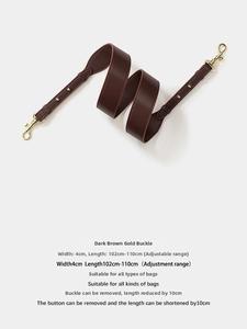 Detail of dark brown leather bag strap with gold buckle and adjustable length measurements