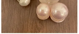 Detail macro view showing the glossy pearl finish on pink mini hair claw clips