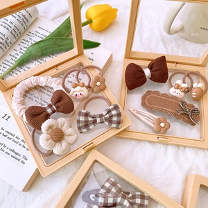 Detail of 5-piece brown and beige fabric hair accessories set in a clear storage box