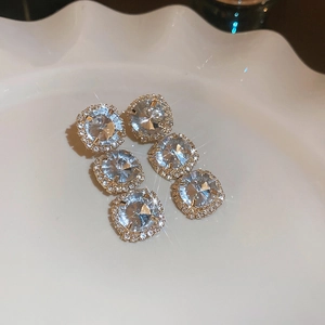 Detail of gold floral earrings with crystal clusters on a white decorative plate