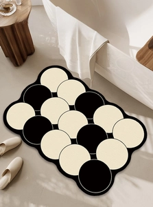 Detail of wave-edged non-slip bath mat with black and white overlapping circle pattern