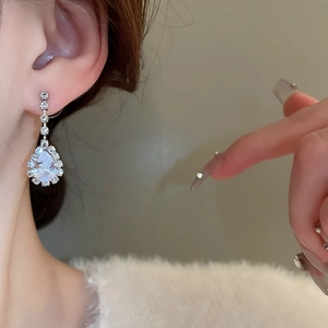 Close-up of elegant V-shape water drop diamond earrings on model for detailed look