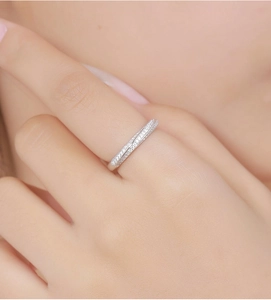 Macro shot of silver Mobius ring with sparkling pavé stones on a model's finger