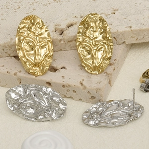 Detail of 304 stainless steel gold and silver wrinkled earrings on natural stone