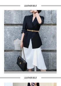 Fashionable slim leather belt in camel with gold buckle worn over a black blazer