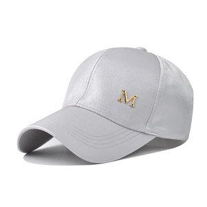 Détail de la casquette de baseball en satin gris avec logo M doré en métal de qualité