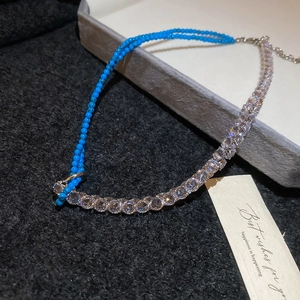 Detail of beaded necklace with turquoise stones and white cubic zirconia claw chain