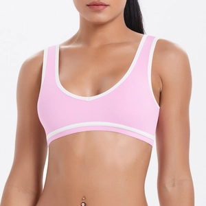 Gros plan sur le liseré contrasté rose et blanc de la brassière de sport de yoga