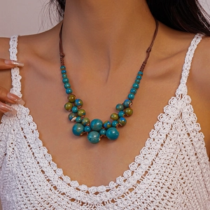 Détail du collier de perles bleu sarcelle à texture rustique sur haut en crochet
