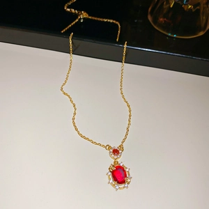 Close-up of 18k gold plated necklace featuring a red oval gemstone and zircon halo
