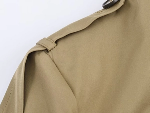 Detailaufnahme der khakifarbenen Jacke mit Köpergewebe, Schulterklappe und braunem Knopf
