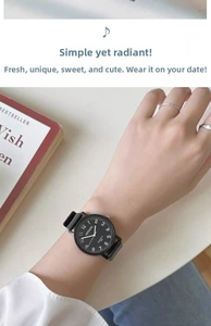 Detail view of a minimalist black quartz watch with clear white numerals on a female wrist