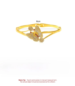 Detailansicht eines Schmetterling-Armreifs mit roten und weißen Kristallen in Gold