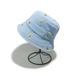 Light blue denim sun hat with cute bear embroidery on a black metal wire hat stand