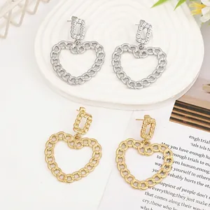 Detail of liquid lava metal heart earrings in gold and silver finish on artistic props