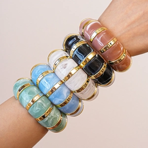Macro shot of geometric acrylic bangle featuring stylish resin and gold metal splicing